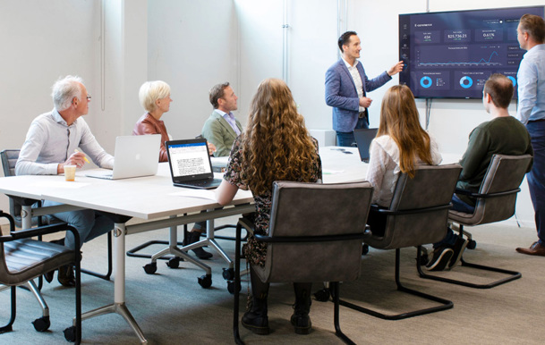 Een groep mensen die rond een tafel zitten